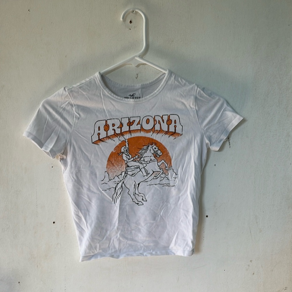 A white crop top with the writing arizona and the graphic of a cowboy
